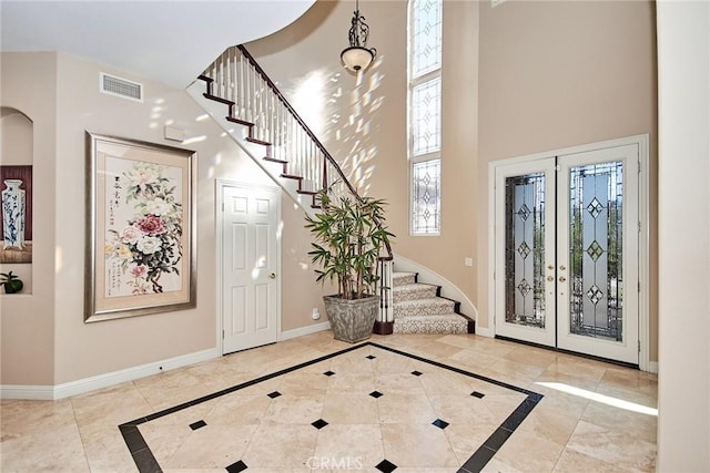 tiled foyer entrance with a towering ceiling