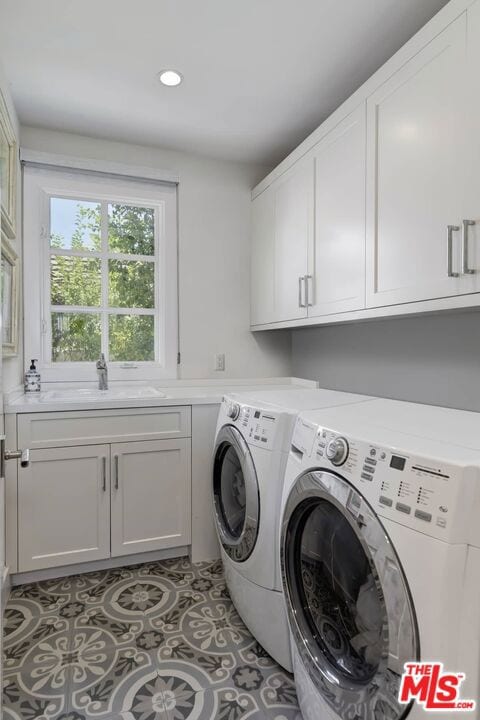 laundry area featuring washer and dryer, cabinets, sink, and tile floors