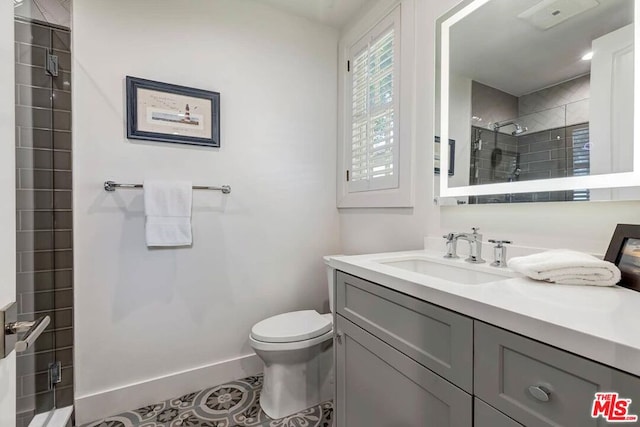 bathroom with a tile shower, tile flooring, toilet, and oversized vanity