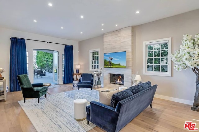 living room with tile walls, hardwood / wood-style flooring, and a tile fireplace