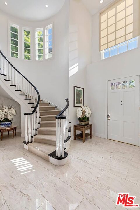 entryway with a high ceiling and light tile flooring