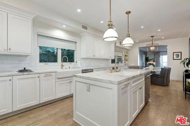 kitchen with backsplash, white cabinetry, light hardwood / wood-style floors, and pendant lighting