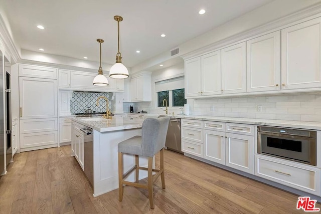 kitchen featuring white cabinetry, tasteful backsplash, light hardwood / wood-style flooring, and stainless steel appliances