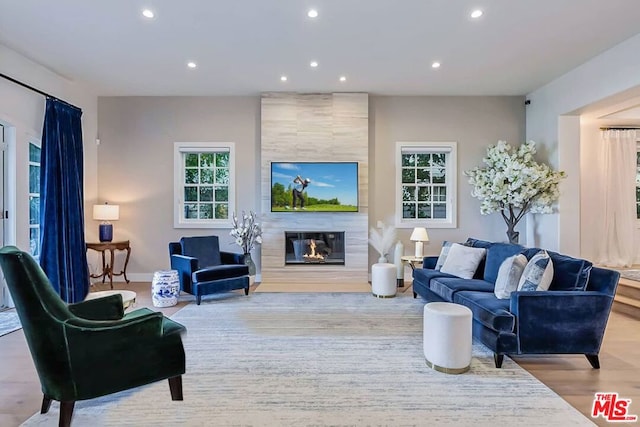 living room featuring a fireplace, hardwood / wood-style flooring, and tile walls