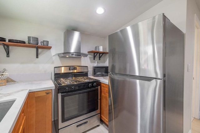 kitchen with light stone countertops, light hardwood / wood-style flooring, ventilation hood, vaulted ceiling, and appliances with stainless steel finishes