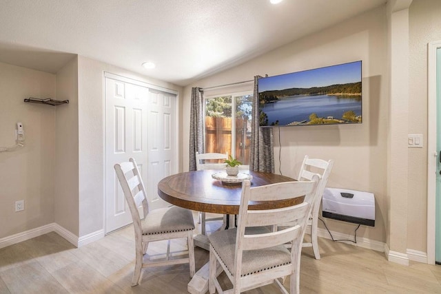 dining area featuring light hardwood / wood-style flooring and lofted ceiling