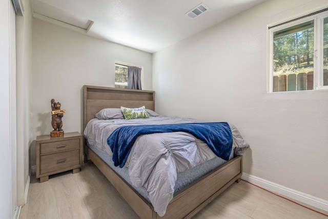 bedroom with multiple windows and light hardwood / wood-style floors