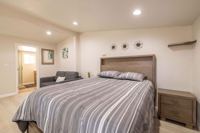 bedroom with ensuite bathroom and light wood-type flooring