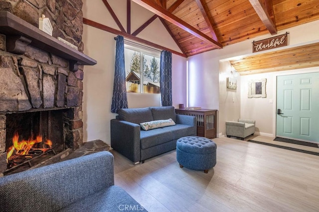 living room with wooden ceiling, a stone fireplace, beamed ceiling, high vaulted ceiling, and light hardwood / wood-style floors