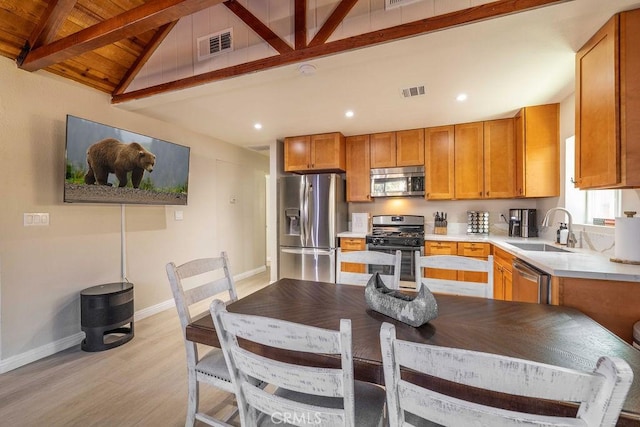 kitchen featuring wooden ceiling, sink, vaulted ceiling with beams, light wood-type flooring, and stainless steel appliances