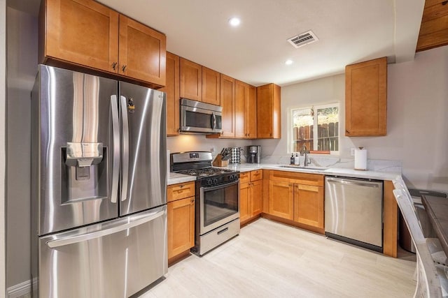 kitchen with sink, light hardwood / wood-style flooring, and appliances with stainless steel finishes