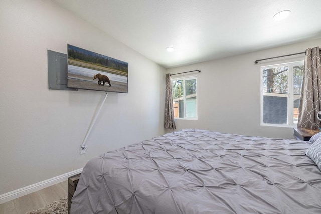 bedroom featuring hardwood / wood-style floors and vaulted ceiling