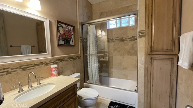 full bathroom with tile walls, backsplash, toilet, bath / shower combo with glass door, and vanity