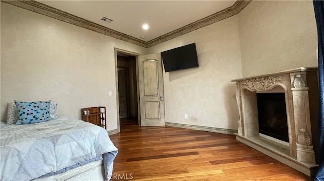 bedroom with hardwood / wood-style floors and crown molding