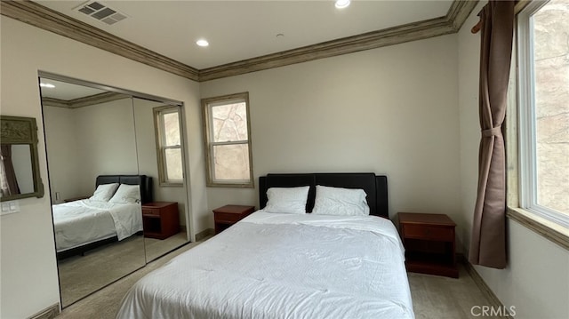 carpeted bedroom with ornamental molding and a closet