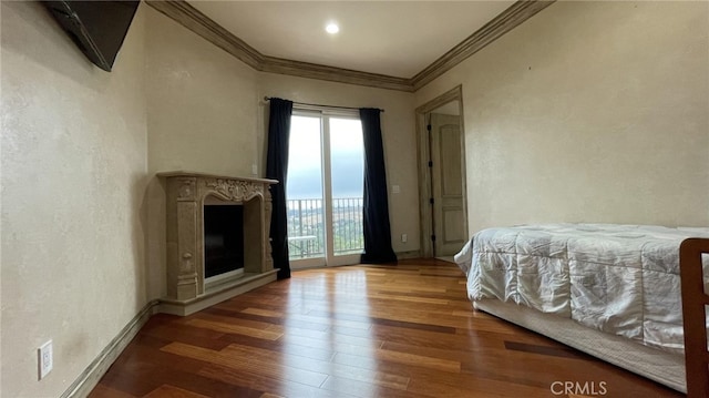 bedroom featuring a fireplace, crown molding, hardwood / wood-style flooring, and access to outside