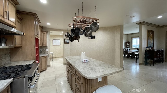 kitchen featuring high end stove, tasteful backsplash, light tile floors, and crown molding