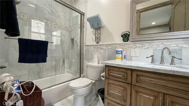 full bathroom with combined bath / shower with glass door, tasteful backsplash, vanity with extensive cabinet space, tile walls, and toilet