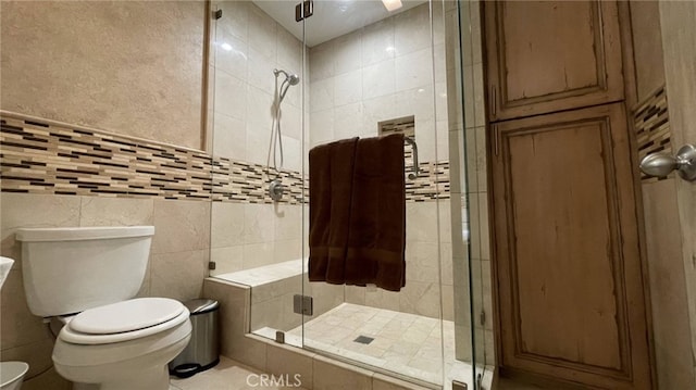 bathroom featuring tile floors, an enclosed shower, toilet, and tile walls