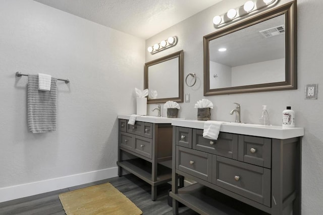 bathroom featuring hardwood / wood-style floors, vanity, and a textured ceiling