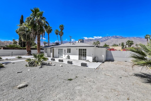 back of property featuring a mountain view and a patio area