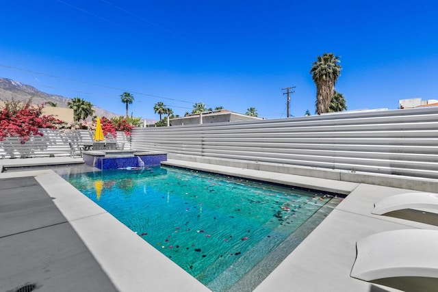 view of pool featuring a patio area, pool water feature, and an in ground hot tub