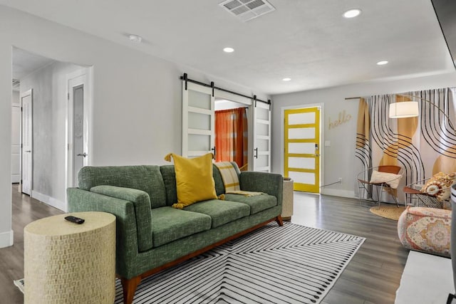 living room featuring wood-type flooring and a barn door