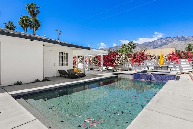 view of swimming pool featuring a mountain view, an in ground hot tub, and a patio area