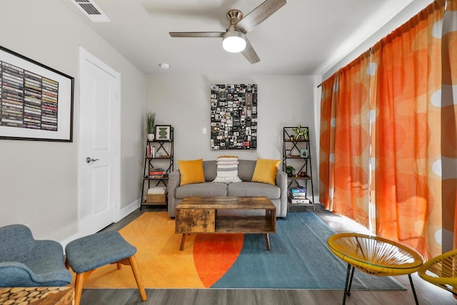 living room featuring wood-type flooring and ceiling fan