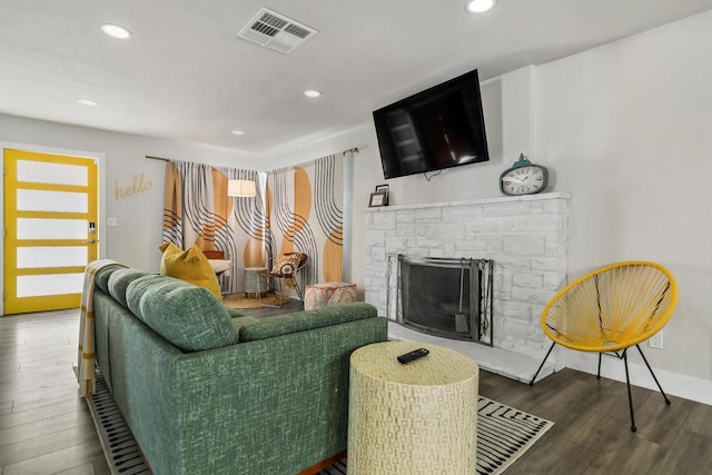 living room featuring a stone fireplace and hardwood / wood-style flooring