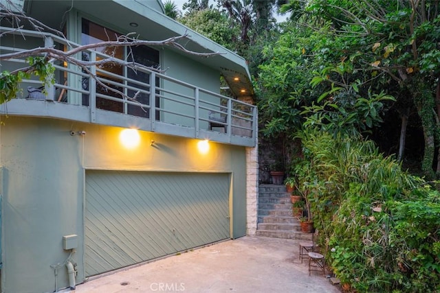 view of side of property with a garage and a balcony