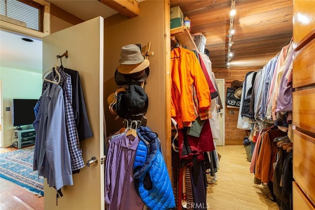 walk in closet with light hardwood / wood-style floors