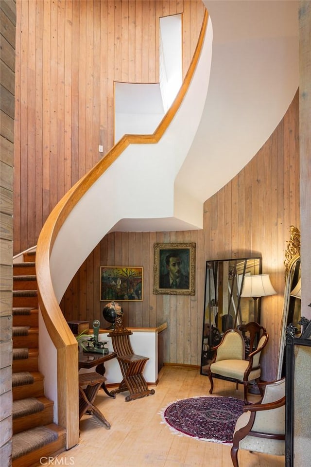 stairs featuring vaulted ceiling and wood walls