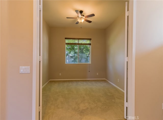 empty room featuring light colored carpet and ceiling fan