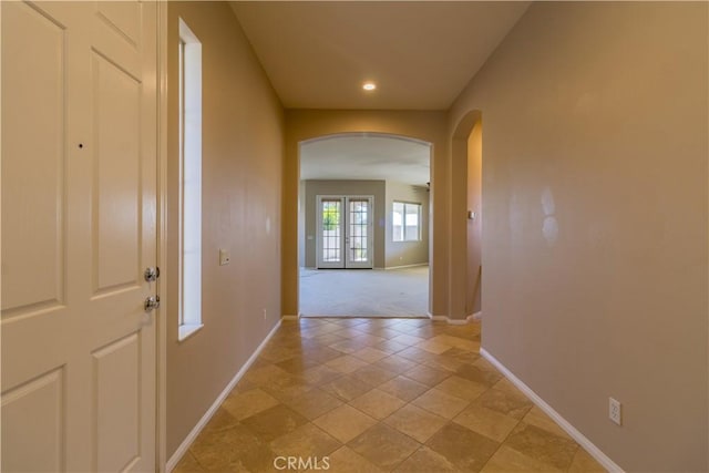 corridor with french doors and light tile patterned floors