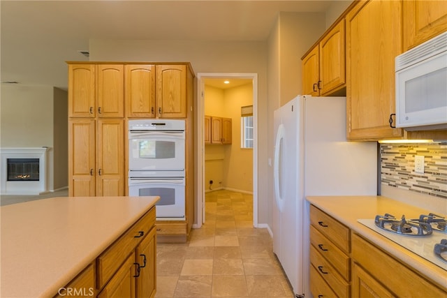 kitchen featuring decorative backsplash, white appliances, and light tile patterned flooring