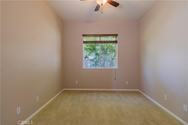 spare room featuring light carpet and ceiling fan