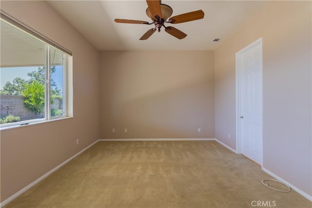 unfurnished room with ceiling fan and light carpet