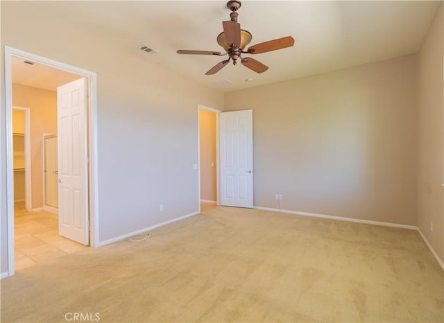 unfurnished bedroom featuring ceiling fan, light colored carpet, and a spacious closet