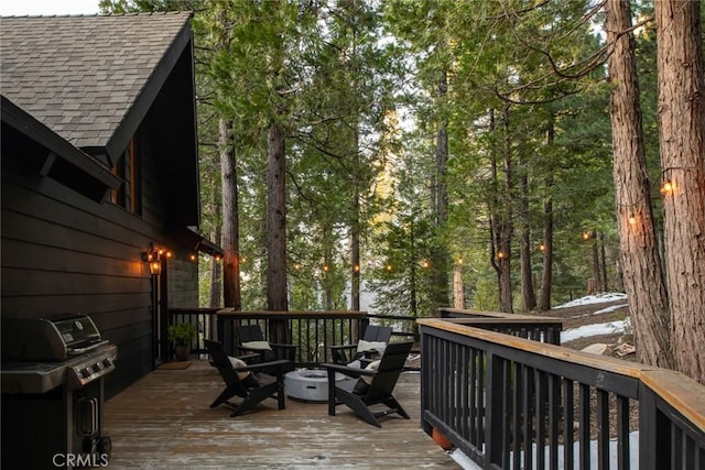 wooden terrace with a grill and a fire pit