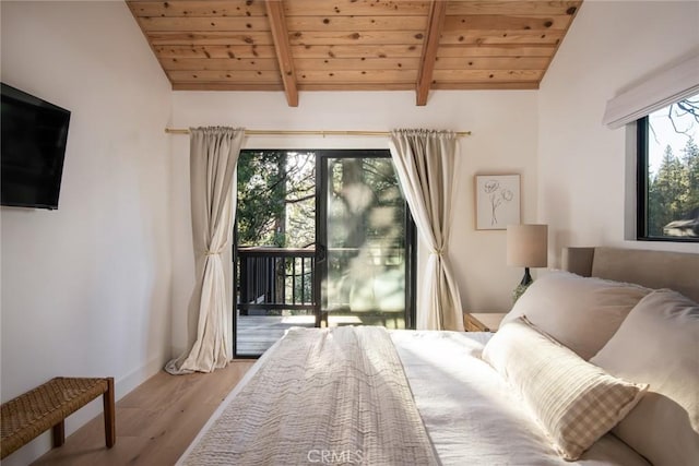 bedroom featuring access to exterior, light wood-type flooring, lofted ceiling with beams, and multiple windows