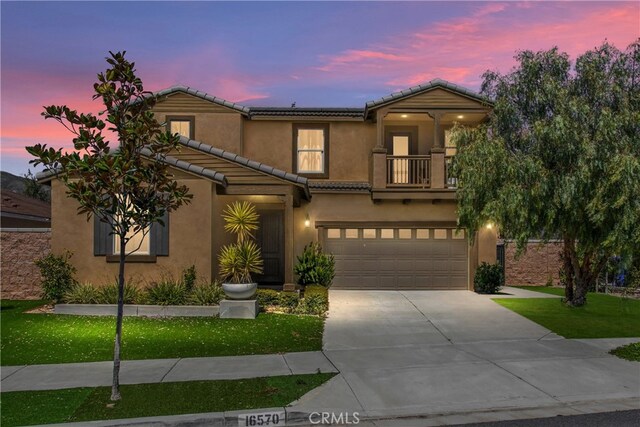 mediterranean / spanish-style house featuring a balcony, a yard, and a garage