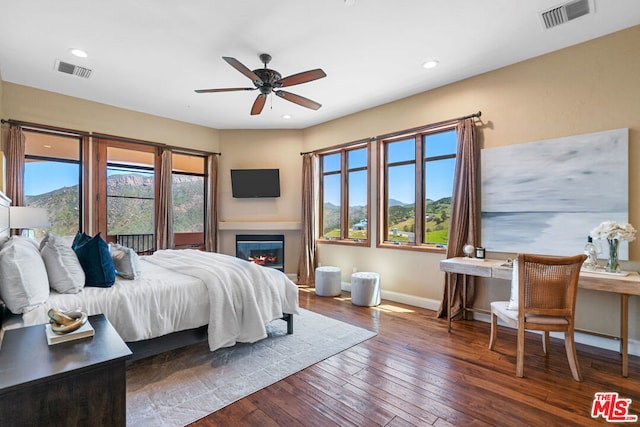 bedroom featuring ceiling fan, dark hardwood / wood-style flooring, and a mountain view