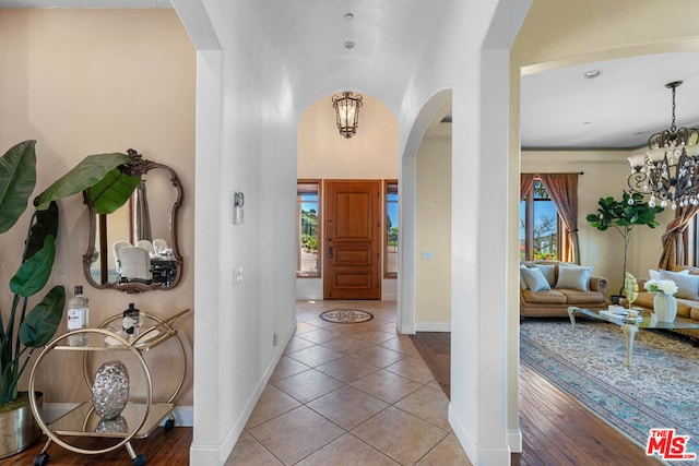 entryway featuring light tile patterned flooring and a chandelier