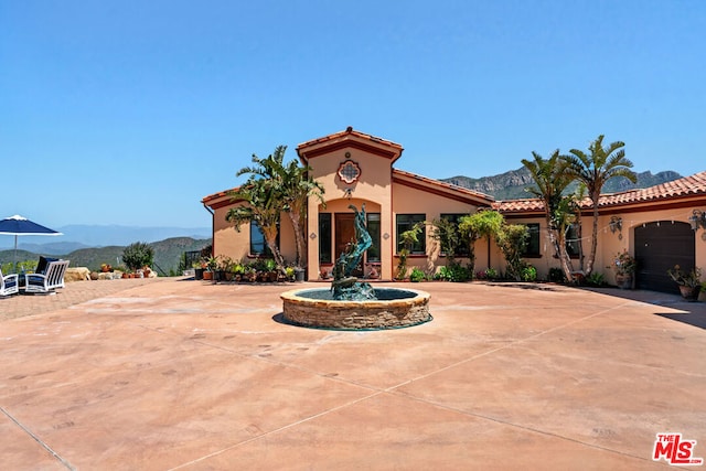 mediterranean / spanish home with a mountain view and a garage