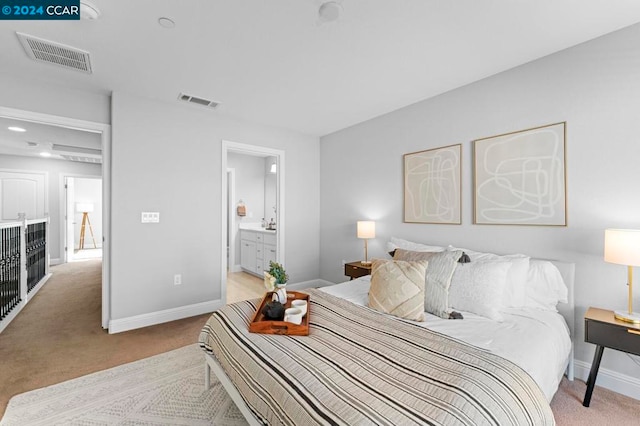 bedroom featuring light carpet and connected bathroom