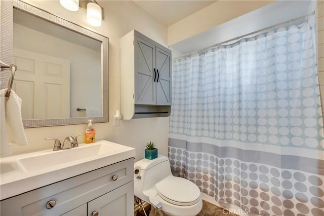 bathroom featuring vanity, walk in shower, and toilet