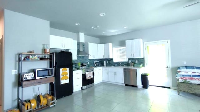 kitchen featuring appliances with stainless steel finishes, light tile flooring, and white cabinetry