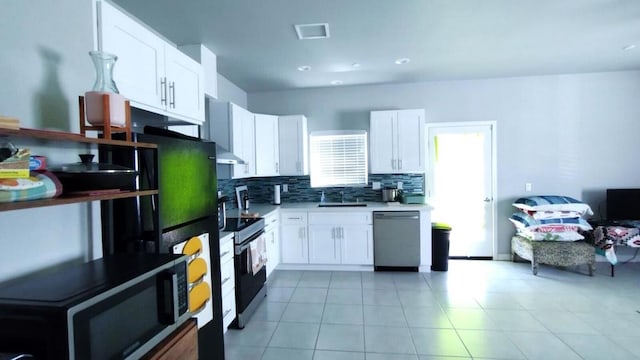 kitchen featuring light tile flooring, white cabinetry, backsplash, electric stove, and dishwasher