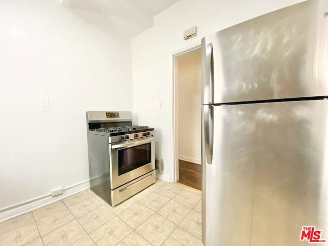 kitchen with appliances with stainless steel finishes and light tile flooring